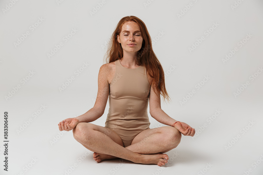 Redhead woman with freckles meditating