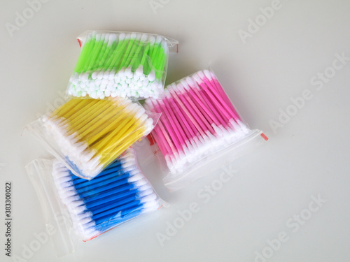 Multi colored ear cleaning buds in packets against white background