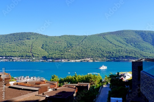 Beautiful panoramic landscape on the emerald bay of the Aegean Sea with green hills, eucalyptus, snow-white yachts. Luxury relax tourism conception