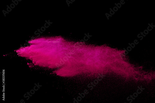 Pink powder explosion on black background. Colored cloud. Colorful dust explode. Paint Holi.