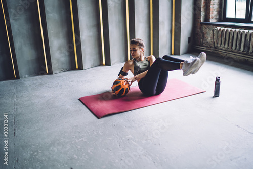 Concentrated woman doing sit ups with ball