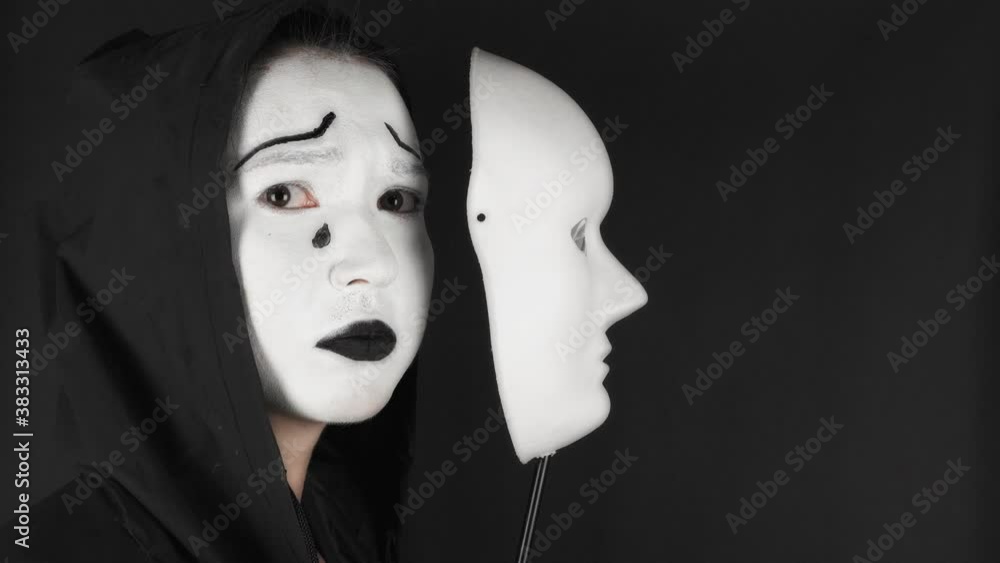 Portrait of a mime and bodypainting woman in white with black lips. Mime woman on black background. Portrait of a mime and bodypainting woman in white with black lips. Mime woman on black background.