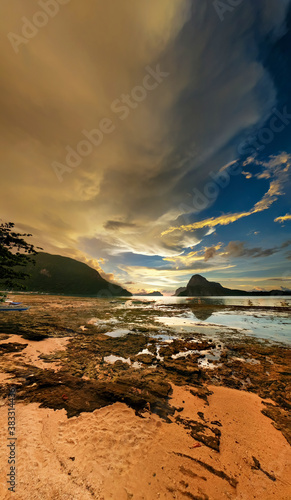 El Nido beach at swallow water, with rocks at shoreline and amazing clouds formation in the background © Ryan