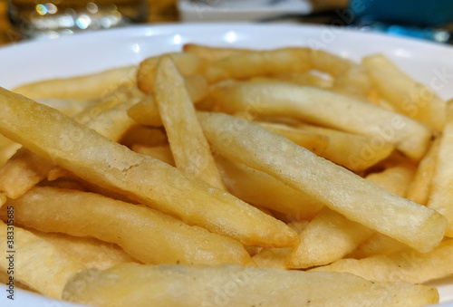 A white plate full of delicious french fries macro isolated snack closeup