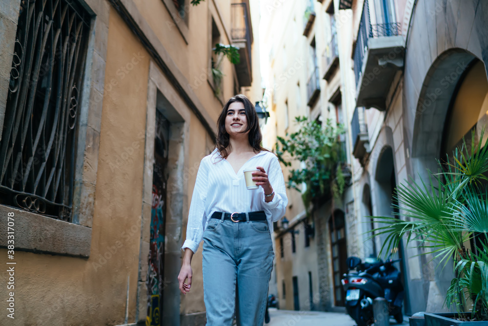 Cheerful woman enjoying coffee during walk