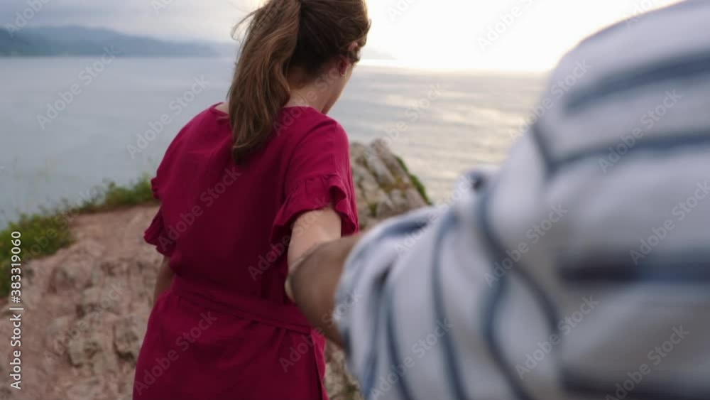 Loving couple kissing on rocky cliff near sea Loving couple kissing on rocky cliff near sea