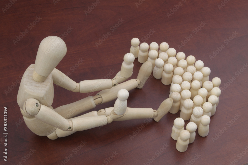 Big wooden mannequin holds two wooden figures, many figures near him. God concept. Big wooden mannequin holds two wooden figures, many figures near him. God concept.