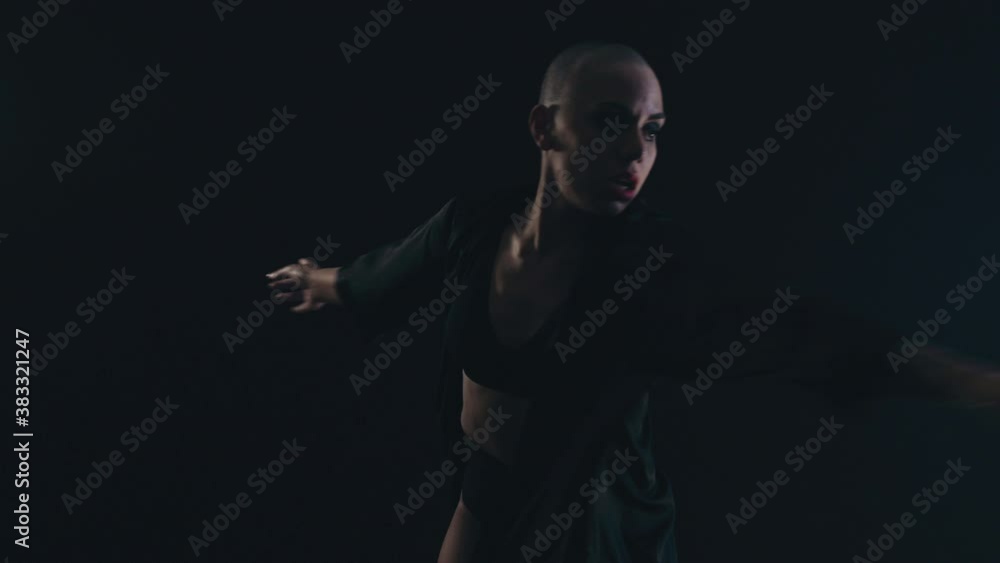 Female agile dancer against a black background dancing and making a pirouette. High quality 4k footage Female agile dancer against a black background dancing and making a pirouette. High quality 4k footage