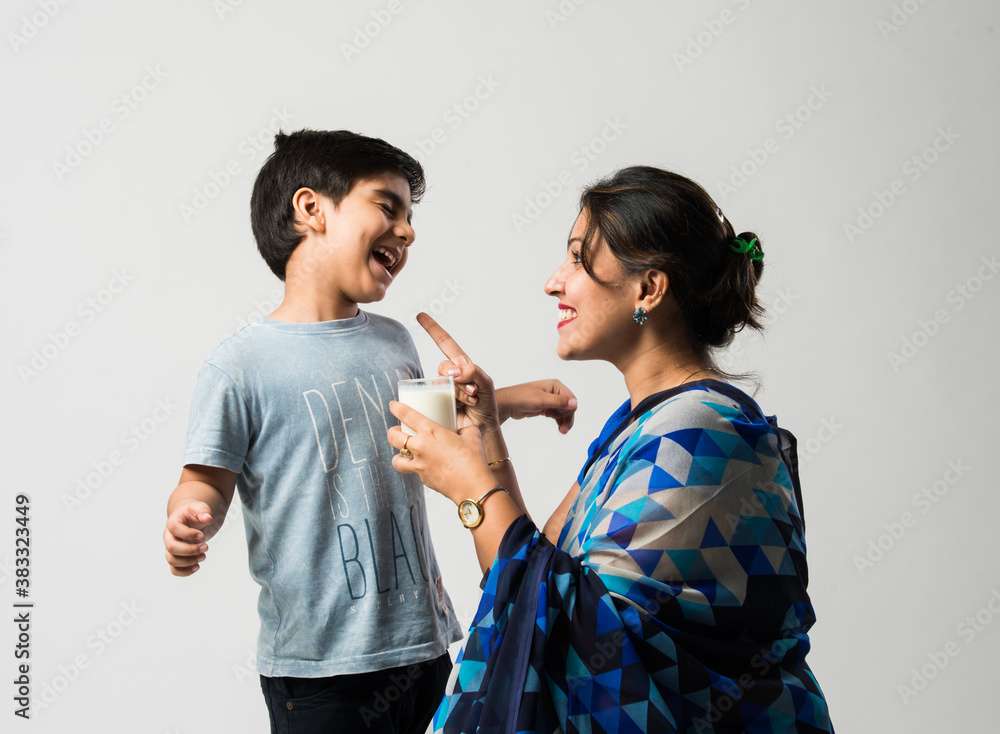 Indian cute boy making tantrums while drinking milk with mother