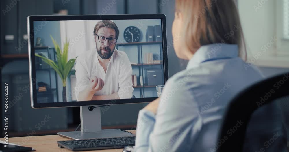Two business colleagues sitting at own office and having working discussion via video call on computer. Focus on screen. Concept of remote cooperation Two business colleagues sitting at own office and having working discussion via video call on computer. Focus on screen. Concept of remote cooperation