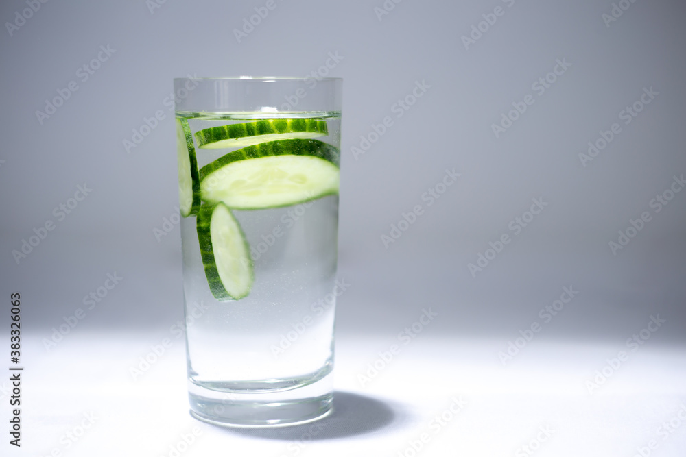 Glass cup with water and cucumber slices