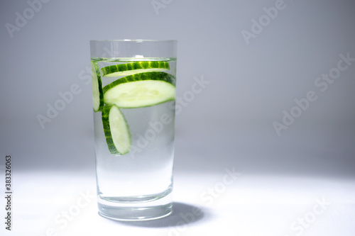 Glass cup with water and cucumber slices