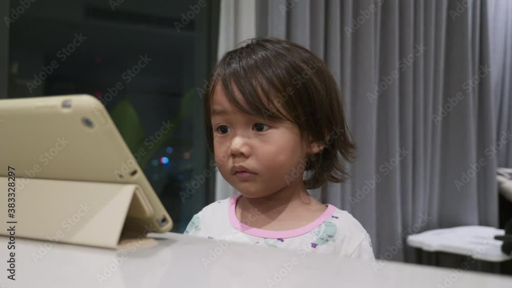 Wideshot of a toddler watching a video on an iPad Tablet. Wideshot of a toddler watching a video on an iPad Tablet.