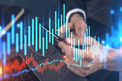Businessman trading stocks using on-line app on phone. Financial graph hologram. © VideoFlow