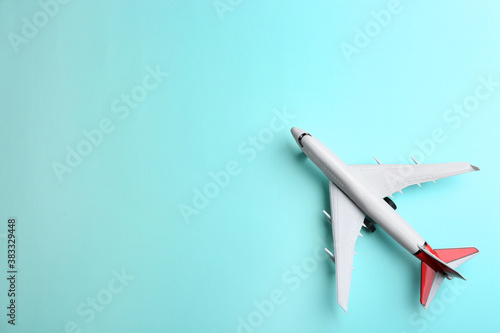 Toy airplane on light blue background, top view. Space for text