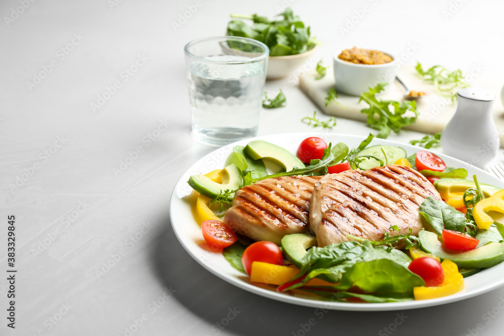 Tasty grilled chicken fillets with vegetables on light grey table. Space for text Tasty grilled chicken fillets with vegetables on light grey table. Space for text