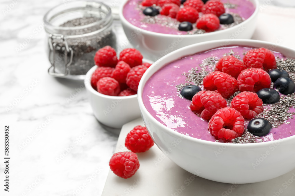 Delicious acai smoothie with raspberries and chia seeds in bowl on white marble table, closeup Delicious acai smoothie with raspberries and chia seeds in bowl on white marble table, closeup