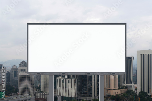 Blank white road billboard with KL cityscape background at day time. Street advertising poster, mock up, 3D rendering. Front view. The concept of marketing communication to promote or sell idea. © VideoFlow