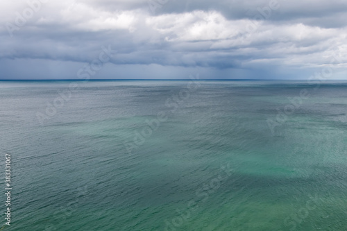 Fototapeta Naklejka Na Ścianę i Meble -  leuchtend grün blauer Ozean mit Wolken am Horizont