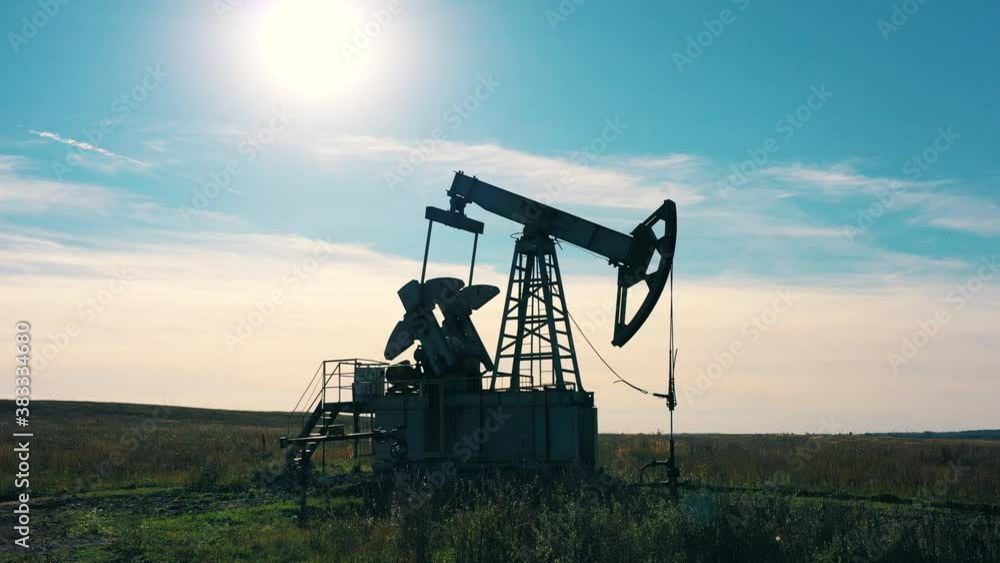 Oil pump jack working in an oilfield. Moving camera Oil pump jack working in an oilfield. Moving camera