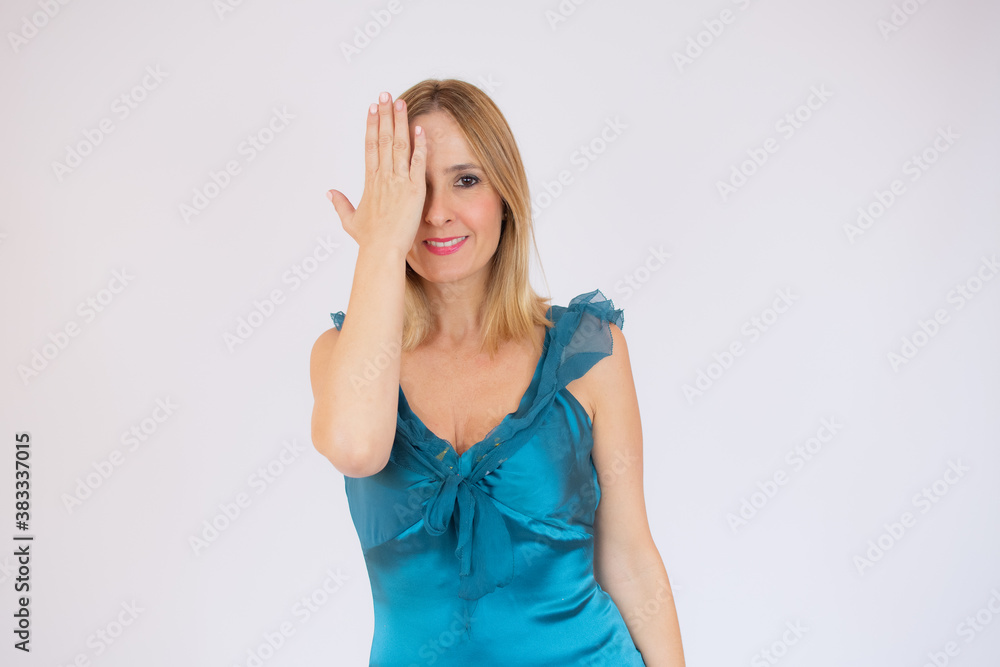 Young celebrating woman blue dress. Beautiful model portrait isolated over studio background Young celebrating woman blue dress. Beautiful model portrait isolated over studio background