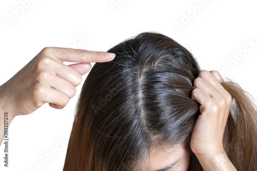 Young woman shows her black gray hair roots on white background