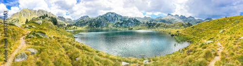 Panoramic view of a beautiful natural lake on a hiking trail in the mountains. Llac del Circ de Colomers, Pirineus, Salardú, Naut Aran, Val d'Aran, Lleida, Catalonia, Spain. photo