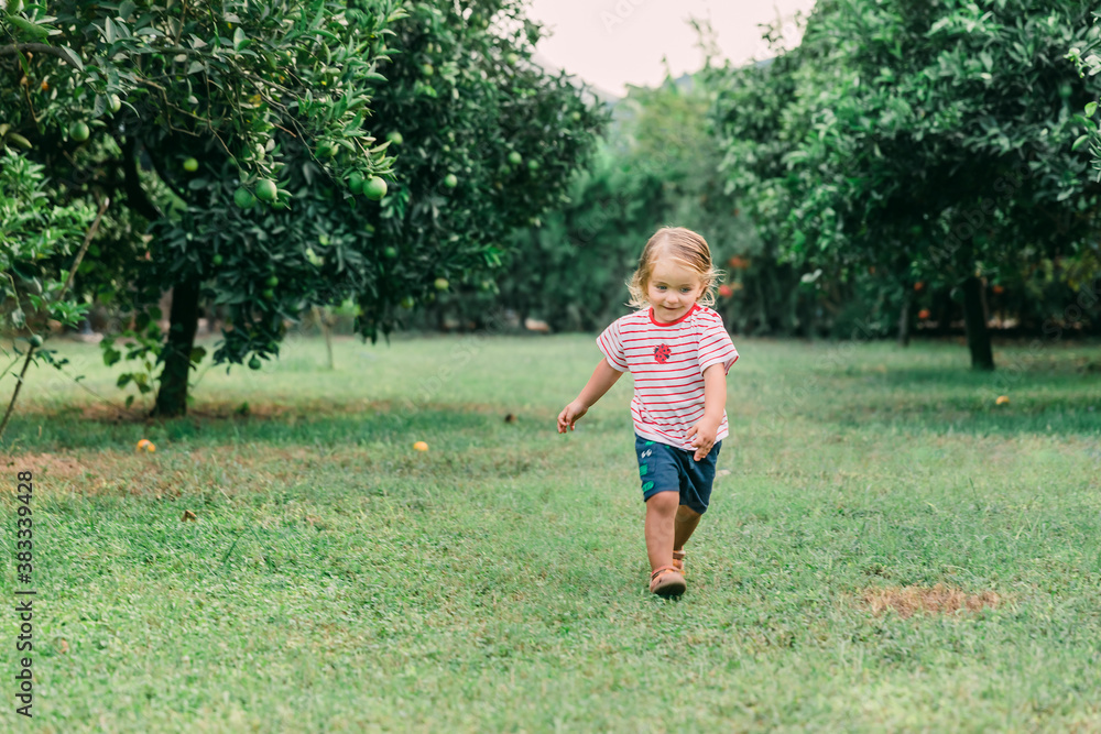 Toddler girl running in garden Toddler girl running in garden