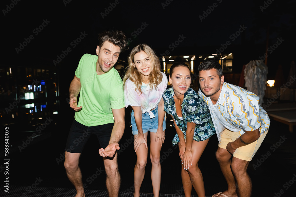 Fototapeta premium Young people looking at camera outdoors at night