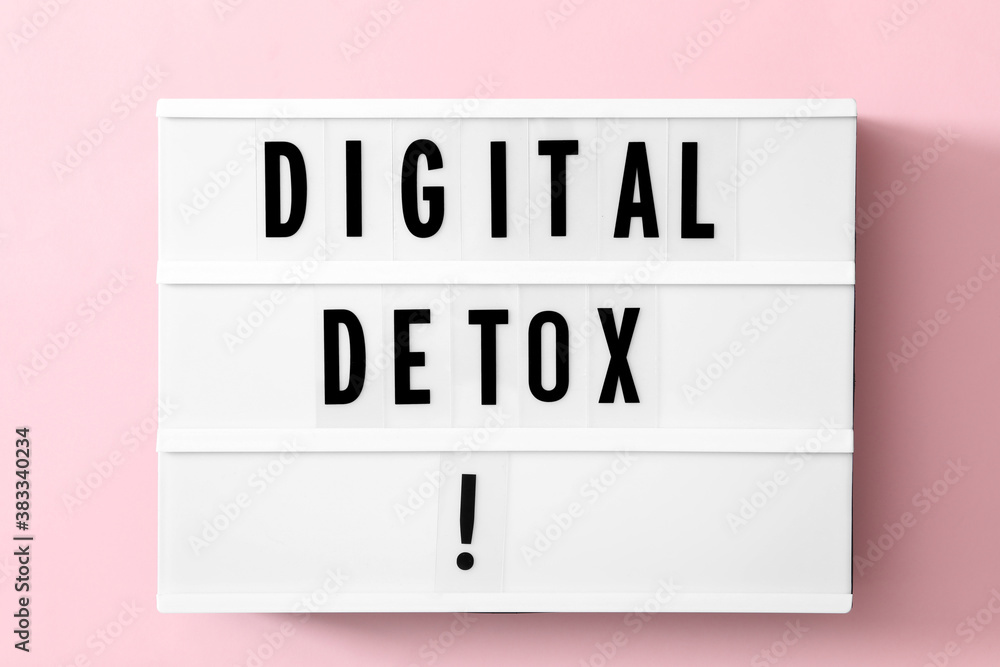 Lightbox with phrase DIGITAL DETOX on pink background, top view Lightbox with phrase DIGITAL DETOX on pink background, top view