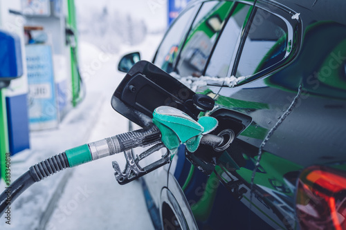 Cropped image of car refueling tanker on gas station with good antifreeze oil and fuel for traveling,automobile with nozzle filling benzine for transportation