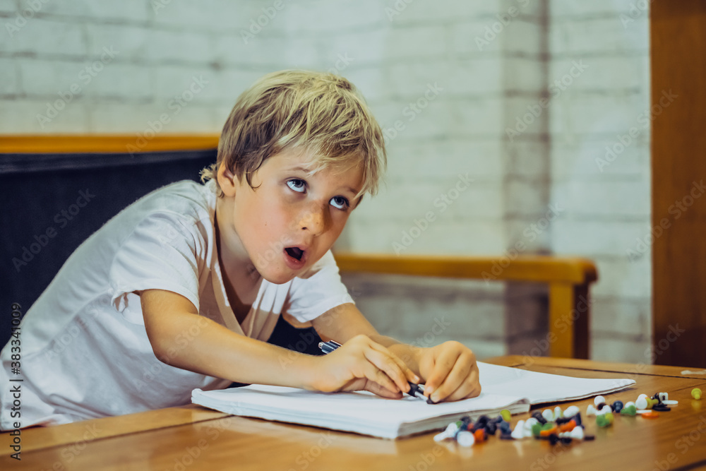 Portrait Preschool boy with open mouth enthusiastically draw holding pen notebook fun learn write, artistic facial expressions gestures. Children behaviour education problems, home school concept Portrait Preschool boy with open mouth enthusiastically draw holding pen notebook fun learn write, artistic facial expressions gestures. Children behaviour education problems, home school concept
