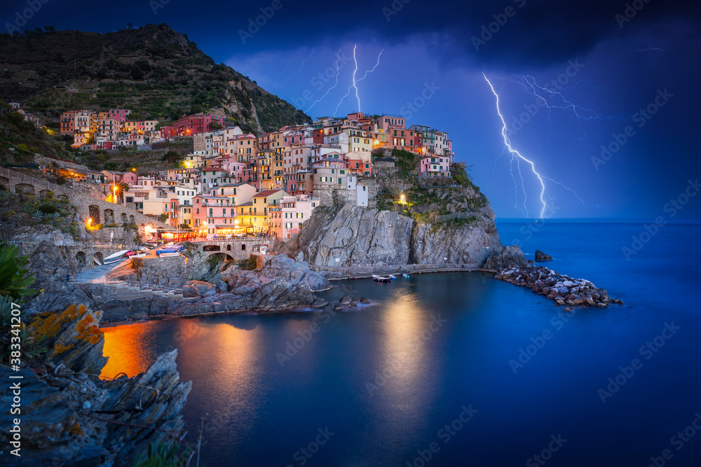 Amazing scenery of Manarola town by the Ligurian Sea with thunderstorms , Italy