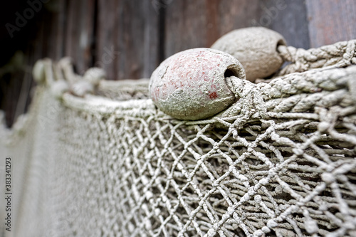 Fototapete Fishing nets hanging on the wall of a boathouse
