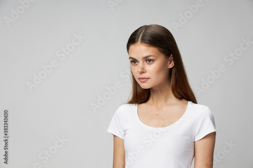Pretty woman look to the side white t-shirt cropped studio view 