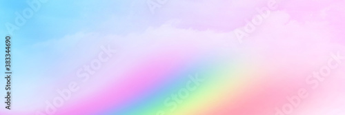 The Rainbow sky is Colorful sky with Soft clouds and a rainbow crossing. Fantasy magical sunny sky pastel background is fluffy white cloud. Freedom wallpaper concept. Sweet color dream. © kikk