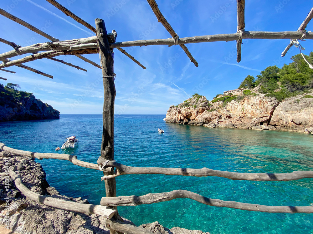 Obraz premium Wooden construction with turquoise sea water in Cala Deia, Mallorca, Spain