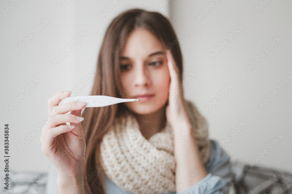 Young Caucasian woman feeling sick and worry while checking her temperature in digital thermometer Young Caucasian woman feeling sick and worry while checking her temperature in digital thermometer