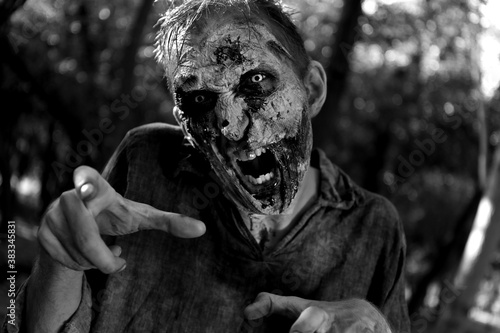 Scary zombie outdoors, black and white effect. Halloween monster