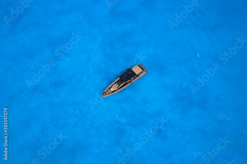 Lonely boat mooring on the water. luxury motor boat. Drone view of a boat. Top view of a boat in the blue sea. Aerial view of a yacht on blue water.