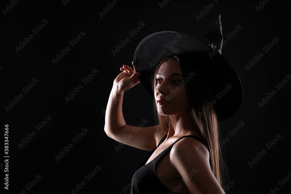 Young woman wearing witch costume on black background, space for text. Halloween party Young woman wearing witch costume on black background, space for text. Halloween party