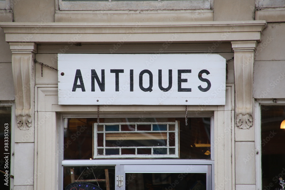 A wood board painted white with the word Antiques in black type. A wood board painted white with the word Antiques in black type.