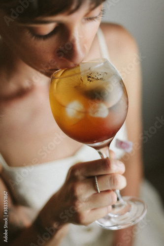 woman in white dress drinking a refreshing cold tea with lemon