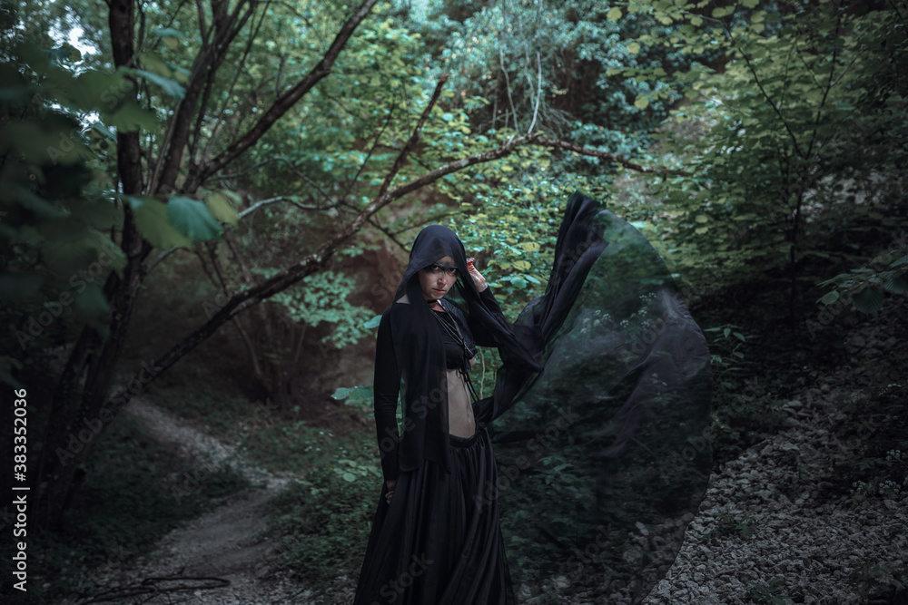 Mysterious sorceress woman witch beautiful black dress walk in gothic forest tree Mysterious sorceress woman witch beautiful black dress walk in gothic forest tree