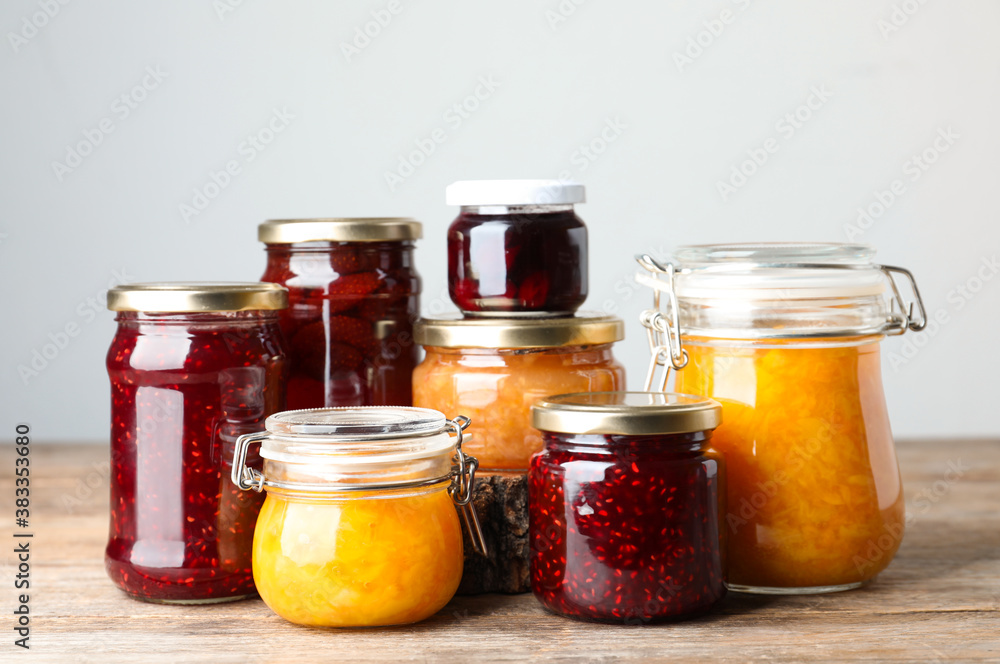 Jars with different jams on wooden table Jars with different jams on wooden table