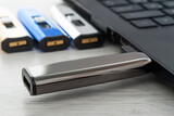 USB flash drive is inserted into the laptop. There are a number of other flash drives in the background