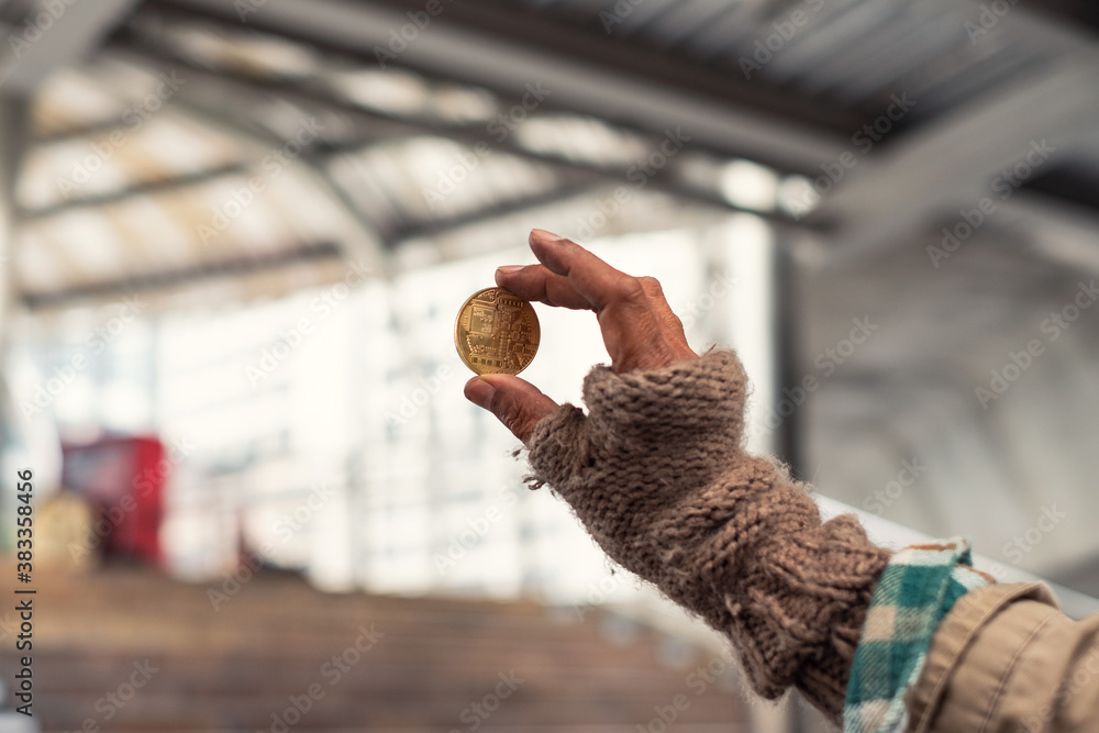 Hand homeless holding gold coin of cryptocurrency
