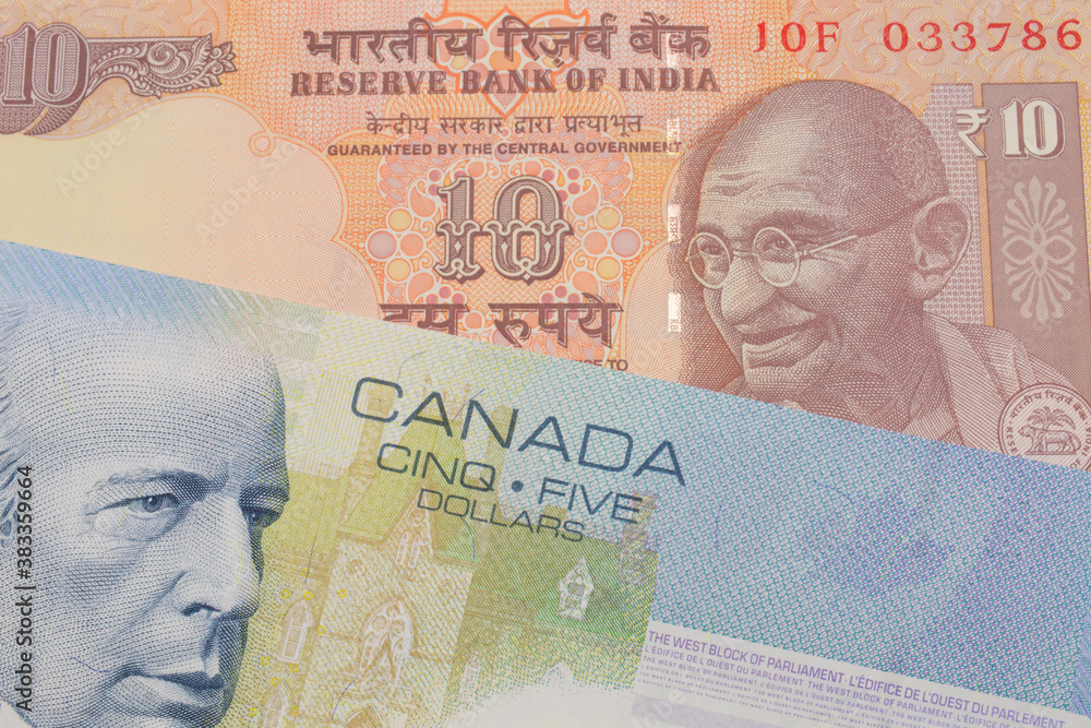 A macro image of a orange ten rupee bill from India paired up with a blue five dollar bill from Canada.  Shot close up in macro.