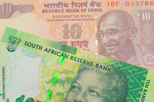 A macro image of a orange ten rupee bill from India paired up with a shiny, green 10 rand bill from South Africa. Shot close up in macro.