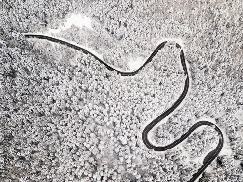 Aerial view of a road winding through snow covered forest © Rafaila Gheorghita